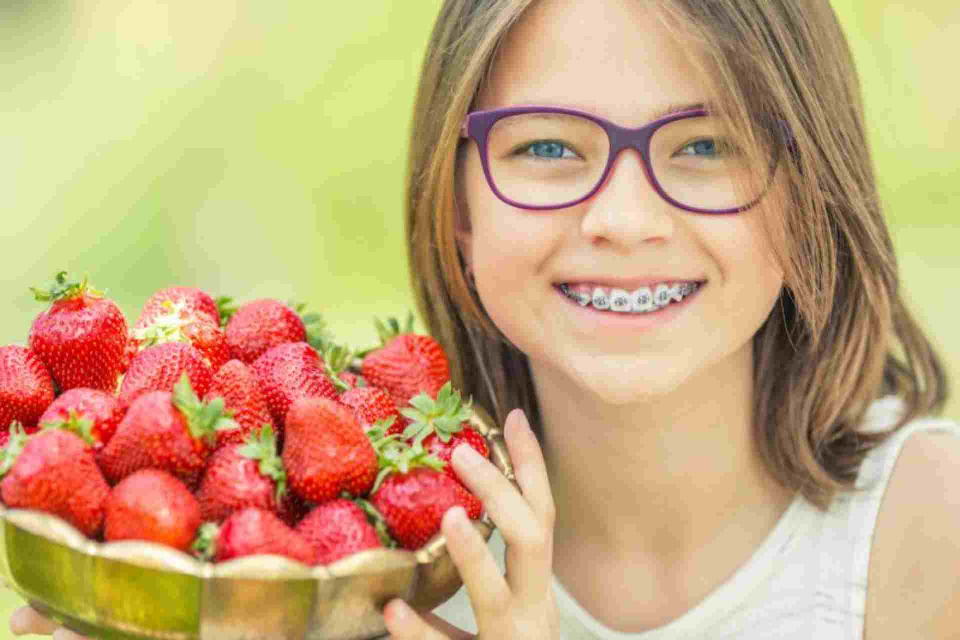 girl with strawberries braces img